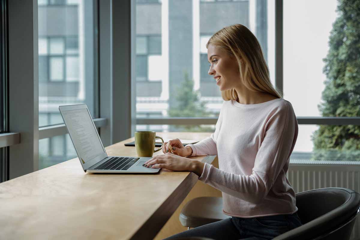 Smiling young woman using a computer before a dental visit